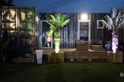 Voiture ancienne blanche décorée de fleurs blanches, stationnée sur un chemin près de vignes et d'un arbre.