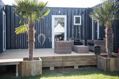 Voiture ancienne blanche décorée de fleurs blanches, stationnée sur un chemin près de vignes et d'un arbre.
