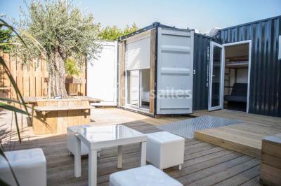 Voiture ancienne blanche décorée de fleurs blanches, stationnée sur un chemin près de vignes et d'un arbre.