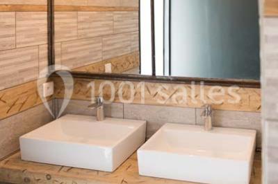 Voiture ancienne blanche décorée de fleurs blanches, stationnée sur un chemin près de vignes et d'un arbre.