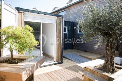 Voiture ancienne blanche décorée de fleurs blanches, stationnée sur un chemin près de vignes et d'un arbre.