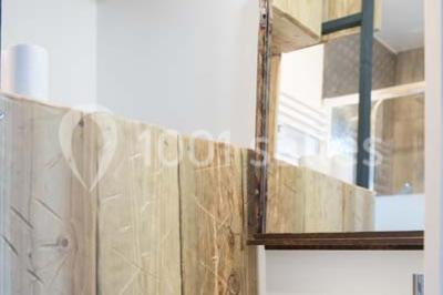 Voiture ancienne blanche décorée de fleurs blanches, stationnée sur un chemin près de vignes et d'un arbre.