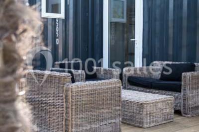 Voiture ancienne blanche décorée de fleurs blanches, stationnée sur un chemin près de vignes et d'un arbre.