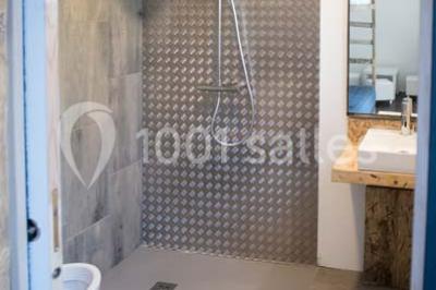 Voiture ancienne blanche décorée de fleurs blanches, stationnée sur un chemin près de vignes et d'un arbre.