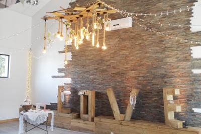 Voiture ancienne blanche décorée de fleurs blanches, stationnée sur un chemin près de vignes et d'un arbre.