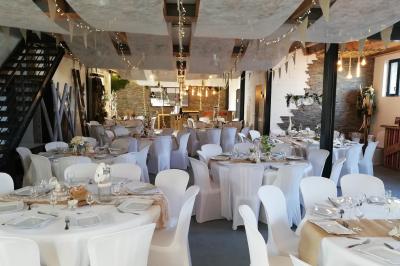 Voiture ancienne blanche décorée de fleurs blanches, stationnée sur un chemin près de vignes et d'un arbre.