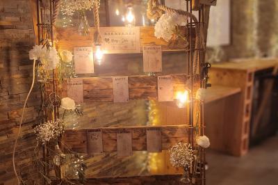 Voiture ancienne blanche décorée de fleurs blanches, stationnée sur un chemin près de vignes et d'un arbre.