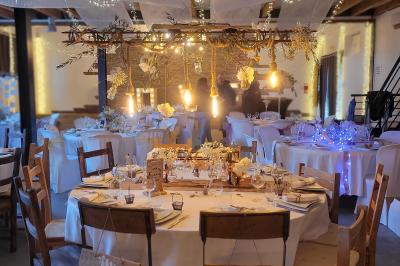 Voiture ancienne blanche décorée de fleurs blanches, stationnée sur un chemin près de vignes et d'un arbre.