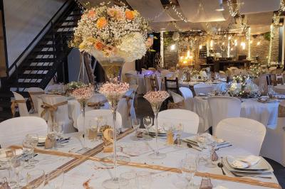 Voiture ancienne blanche décorée de fleurs blanches, stationnée sur un chemin près de vignes et d'un arbre.