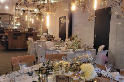 Voiture ancienne blanche décorée de fleurs blanches, stationnée sur un chemin près de vignes et d'un arbre.