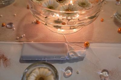 Voiture ancienne blanche décorée de fleurs blanches, stationnée sur un chemin près de vignes et d'un arbre.