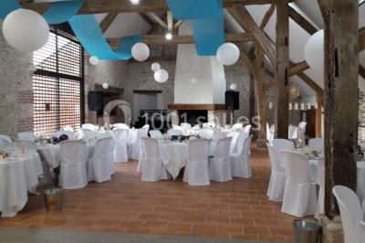 Chambre avec un lit double, tête de lit noire, tables de chevet, mur bleu et mobilier sombre sur un sol en parquet clair.
