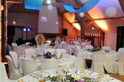 Chambre avec un lit double, tête de lit noire, tables de chevet, mur bleu et mobilier sombre sur un sol en parquet clair.