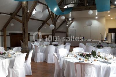 Chambre avec un lit double, tête de lit noire, tables de chevet, mur bleu et mobilier sombre sur un sol en parquet clair.