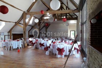 Chambre avec un lit double, tête de lit noire, tables de chevet, mur bleu et mobilier sombre sur un sol en parquet clair.