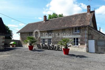 Chambre avec un lit double, tête de lit noire, tables de chevet, mur bleu et mobilier sombre sur un sol en parquet clair.