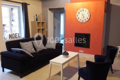 Chambre avec un lit double, tête de lit noire, tables de chevet, mur bleu et mobilier sombre sur un sol en parquet clair.