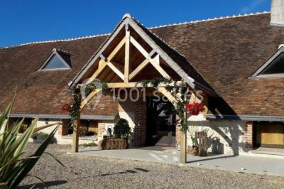 Chambre avec un lit double, tête de lit noire, tables de chevet, mur bleu et mobilier sombre sur un sol en parquet clair.