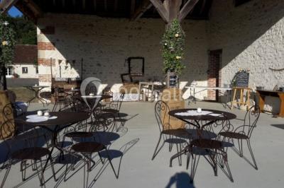 Chambre avec un lit double, tête de lit noire, tables de chevet, mur bleu et mobilier sombre sur un sol en parquet clair.