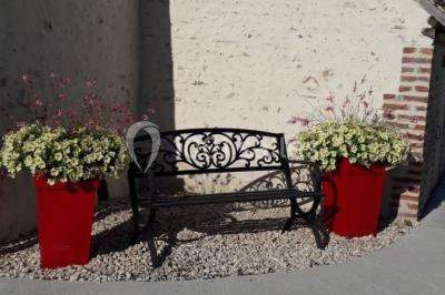 Chambre avec un lit double, tête de lit noire, tables de chevet, mur bleu et mobilier sombre sur un sol en parquet clair.