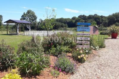 Chambre avec un lit double, tête de lit noire, tables de chevet, mur bleu et mobilier sombre sur un sol en parquet clair.