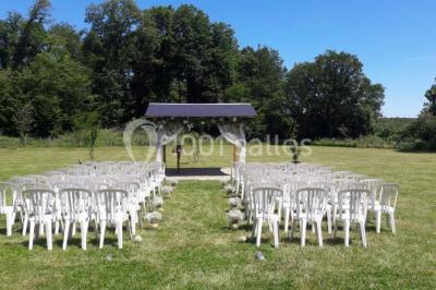 Chambre avec un lit double, tête de lit noire, tables de chevet, mur bleu et mobilier sombre sur un sol en parquet clair.