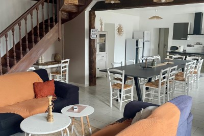 Tonneau en bois transformé en bar avec décoration végétale, verres et pancarte ’Servez-vous’ dans un jardin.