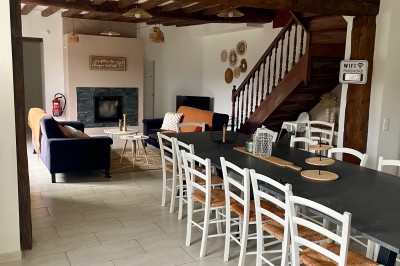 Tonneau en bois transformé en bar avec décoration végétale, verres et pancarte ’Servez-vous’ dans un jardin.