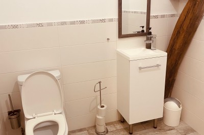 Tonneau en bois transformé en bar avec décoration végétale, verres et pancarte ’Servez-vous’ dans un jardin.