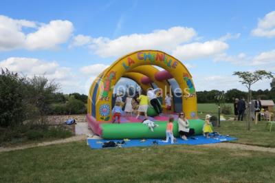 Chambre avec lits superposés en bois, parquet, papier peint floral, accès à une salle de bain et vue sur un jardin.