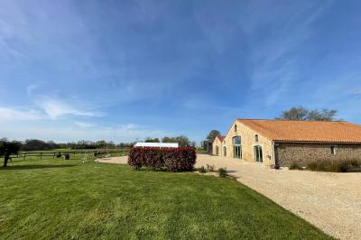 Chambre avec lits superposés en bois, parquet, papier peint floral, accès à une salle de bain et vue sur un jardin.