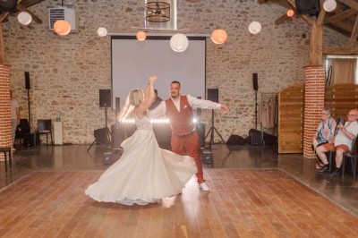 Chambre avec lits superposés en bois, parquet, papier peint floral, accès à une salle de bain et vue sur un jardin.