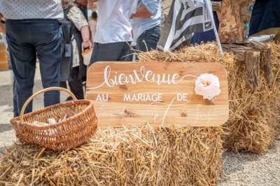 Chambre avec lits superposés en bois, parquet, papier peint floral, accès à une salle de bain et vue sur un jardin.