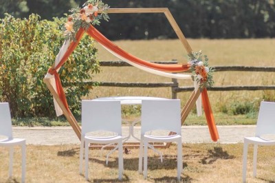 Chambre avec lits superposés en bois, parquet, papier peint floral, accès à une salle de bain et vue sur un jardin.
