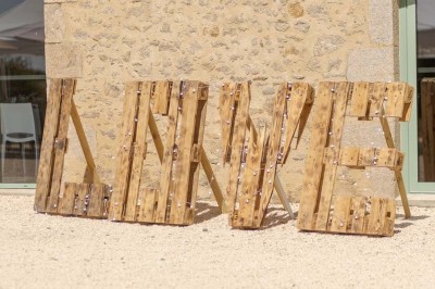 Chambre avec lits superposés en bois, parquet, papier peint floral, accès à une salle de bain et vue sur un jardin.