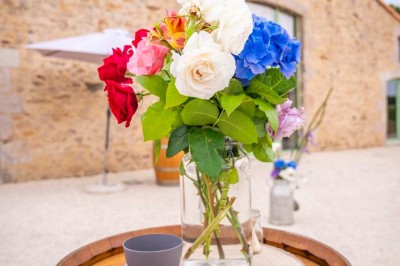 Chambre avec lits superposés en bois, parquet, papier peint floral, accès à une salle de bain et vue sur un jardin.
