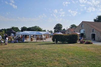 Chambre avec lits superposés en bois, parquet, papier peint floral, accès à une salle de bain et vue sur un jardin.