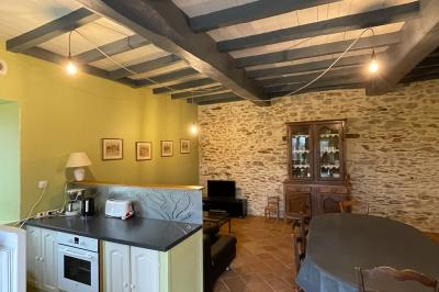 Chambre avec lits superposés en bois, parquet, papier peint floral, accès à une salle de bain et vue sur un jardin.