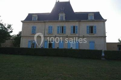 Salle de réception avec une piste de danse, une table dressée à gauche et un équipement de sonorisation au centre.