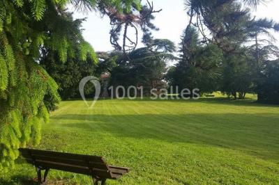 Salle de réception avec une piste de danse, une table dressée à gauche et un équipement de sonorisation au centre.