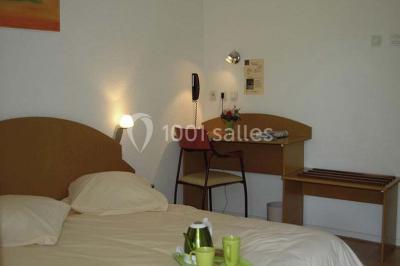 Salle de réception avec une piste de danse, une table dressée à gauche et un équipement de sonorisation au centre.