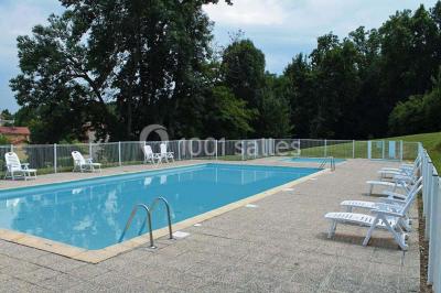 Salle de réception avec une piste de danse, une table dressée à gauche et un équipement de sonorisation au centre.