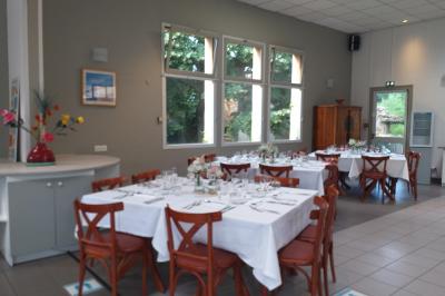 Salle de réception avec une piste de danse, une table dressée à gauche et un équipement de sonorisation au centre.