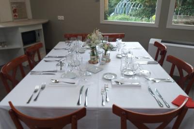 Salle de réception avec une piste de danse, une table dressée à gauche et un équipement de sonorisation au centre.
