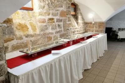 Salle de réception avec une piste de danse, une table dressée à gauche et un équipement de sonorisation au centre.
