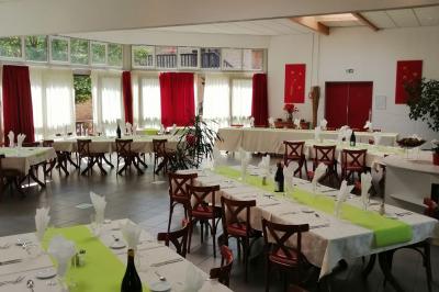 Salle de réception avec une piste de danse, une table dressée à gauche et un équipement de sonorisation au centre.