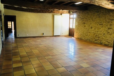 Miniature Location salle Podensac (Gironde) - Maison des Vins de Graves #8 Salle spacieuse avec sol en carrelage, mezzanine en bois, murs en pierre et porte vitrée ouverte.