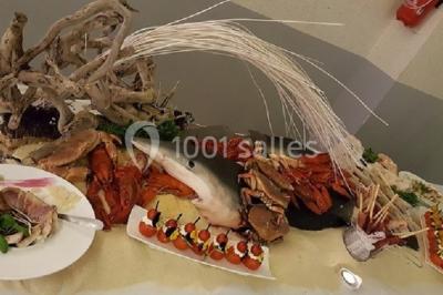 Plateau de fruits de mer et poissons décoré avec des crustacés, un requin et des éléments végétaux sur une table.