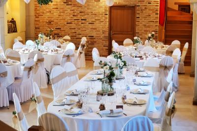 Façade d'une maison en briques et bois avec fenêtres à volets, entourée de végétation et baignée de lumière naturelle.