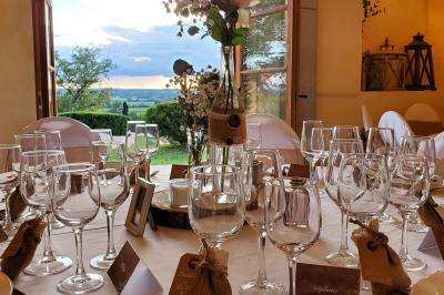 Façade d'une maison en briques et bois avec fenêtres à volets, entourée de végétation et baignée de lumière naturelle.